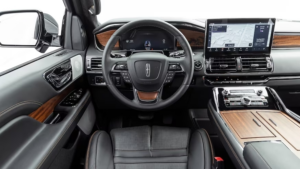 Luxury car interior with black leather seats, wood trim, and a large digital dashboard display