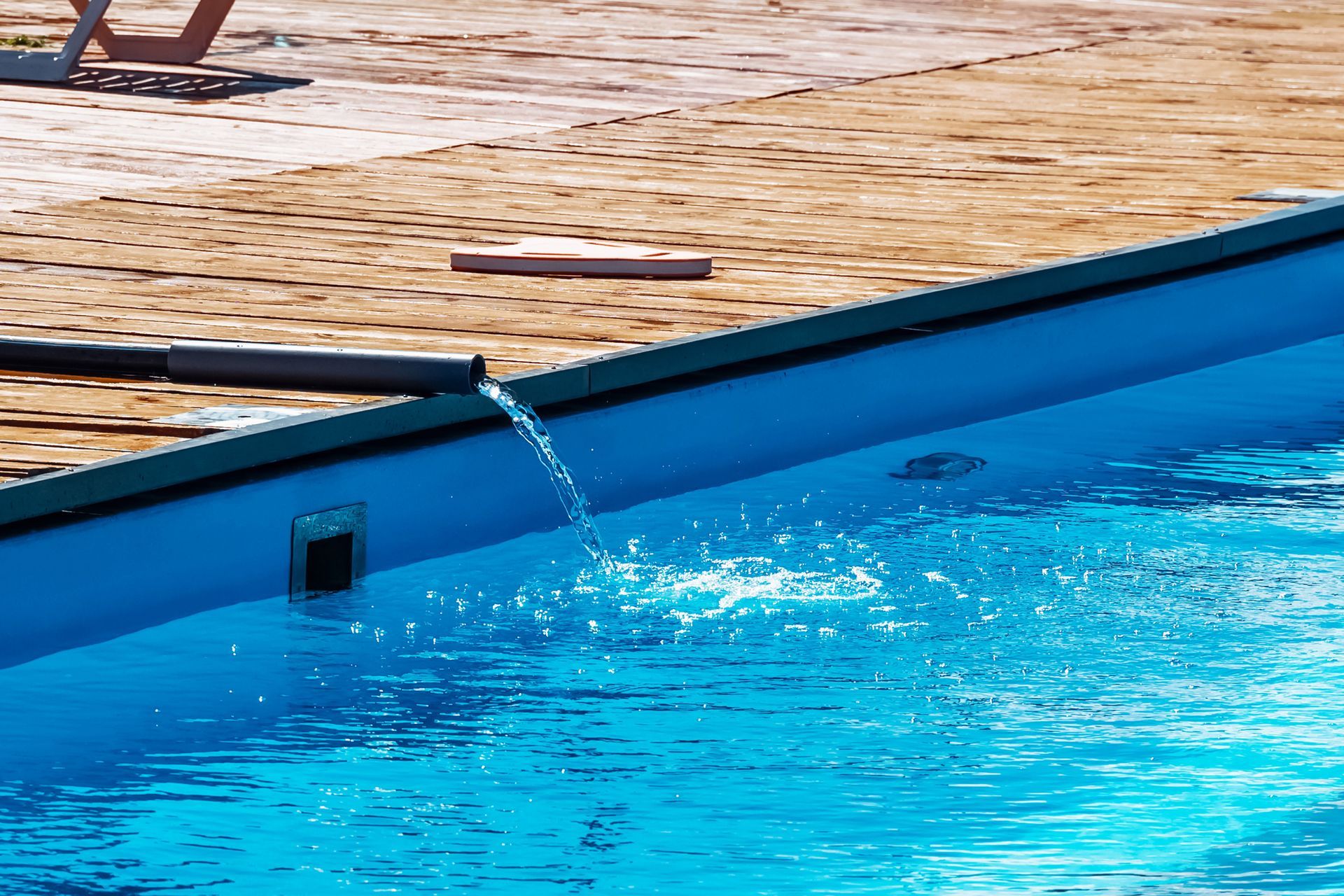 A pool is filled with clean tap water from a hose. A pool is filled with clean tap water from a hose.