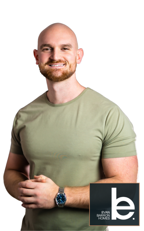 A bald man with a beard is wearing a green shirt and a watch.