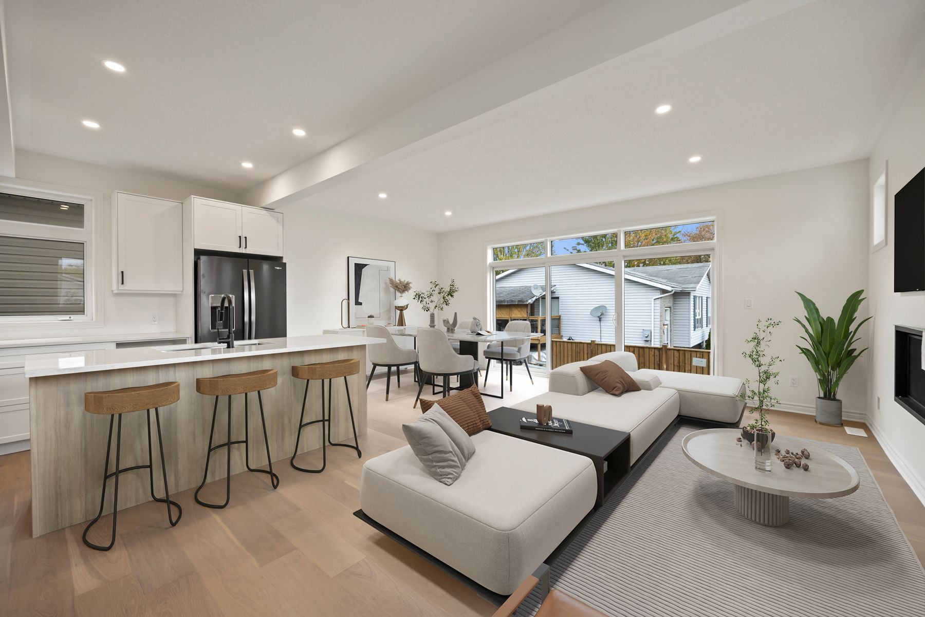 A living room with a couch, coffee table, stools and a kitchen.