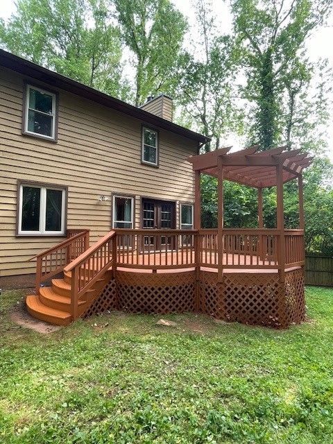 Two-tier wooden deck renovation featuring a built-in pergola and matching lattice skirting.