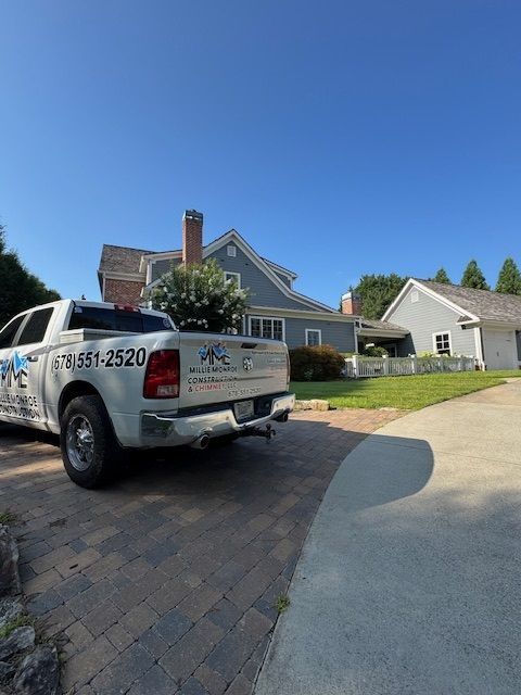 White pickup truck parked in front of a suburban house on a sunny day