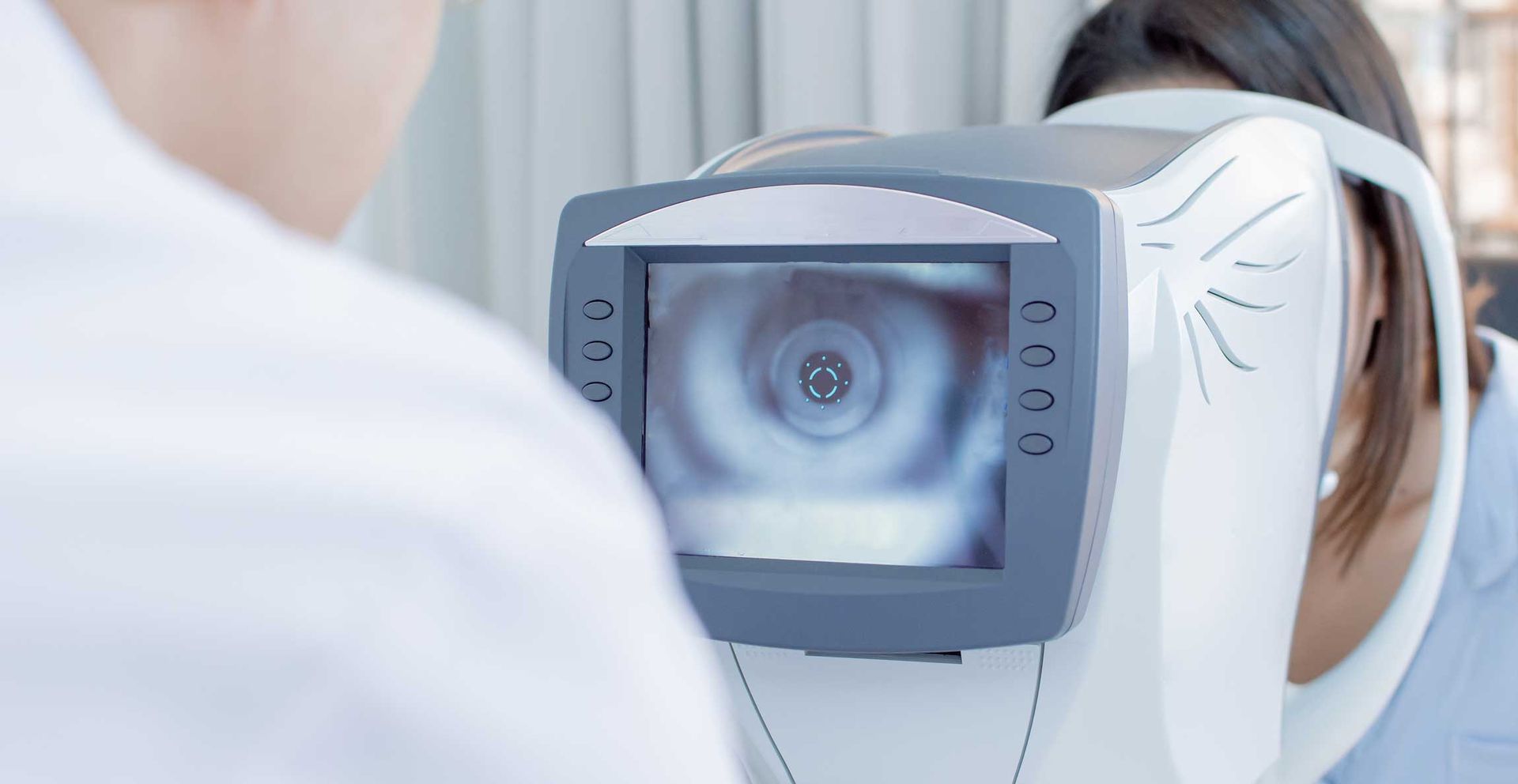 Eye exam machine being used in a clinic, with a patient looking into the device