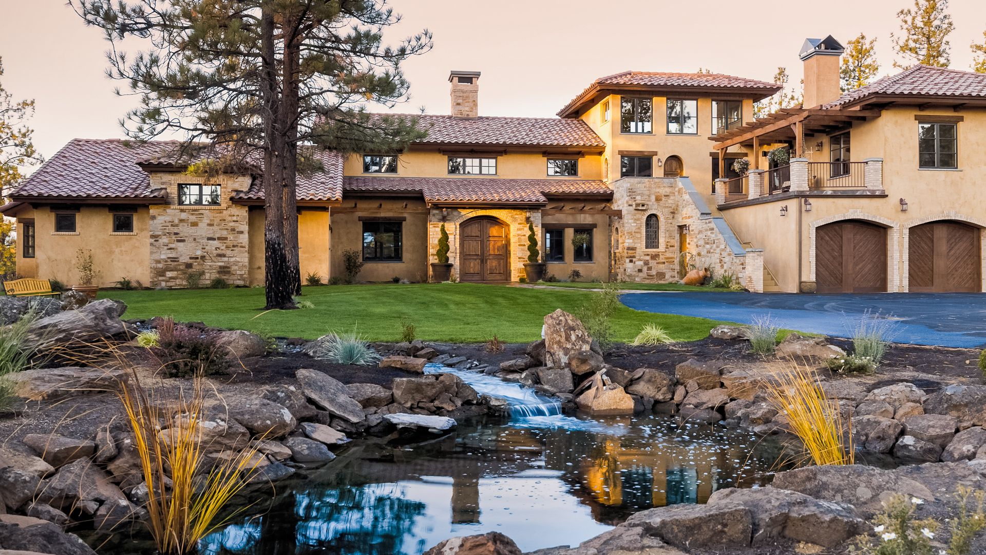 a large house with a pond in front of it