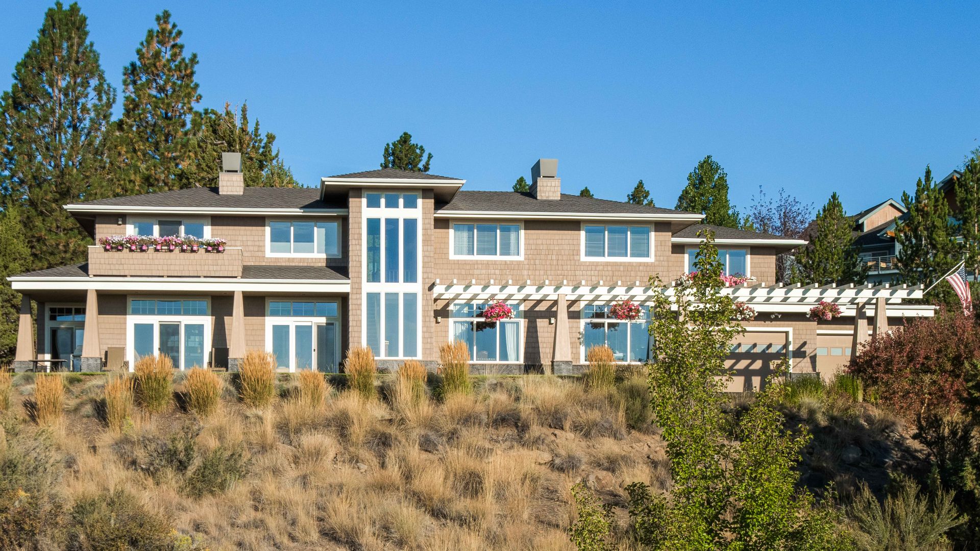 a large house is sitting on top of a hill surrounded by trees .