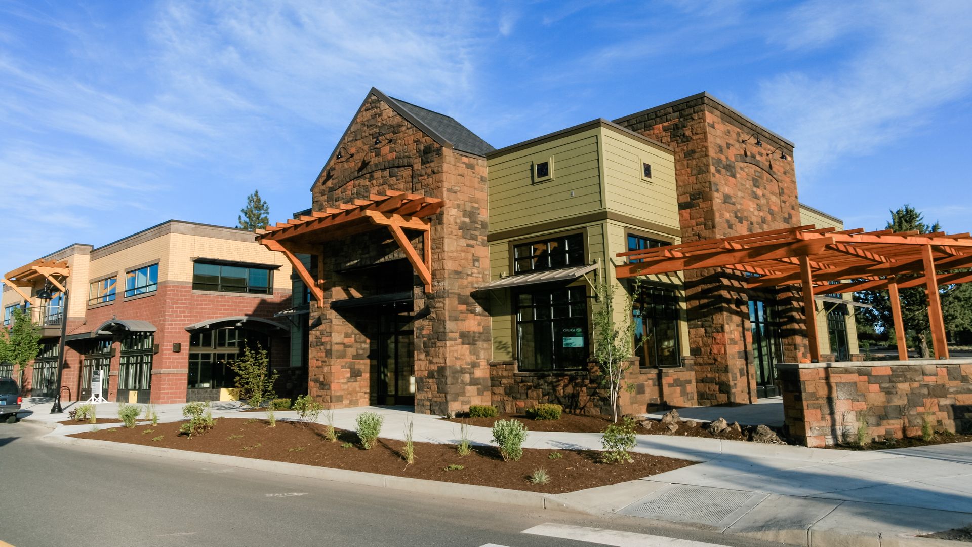 a large building with a lot of windows is sitting on the side of the road .