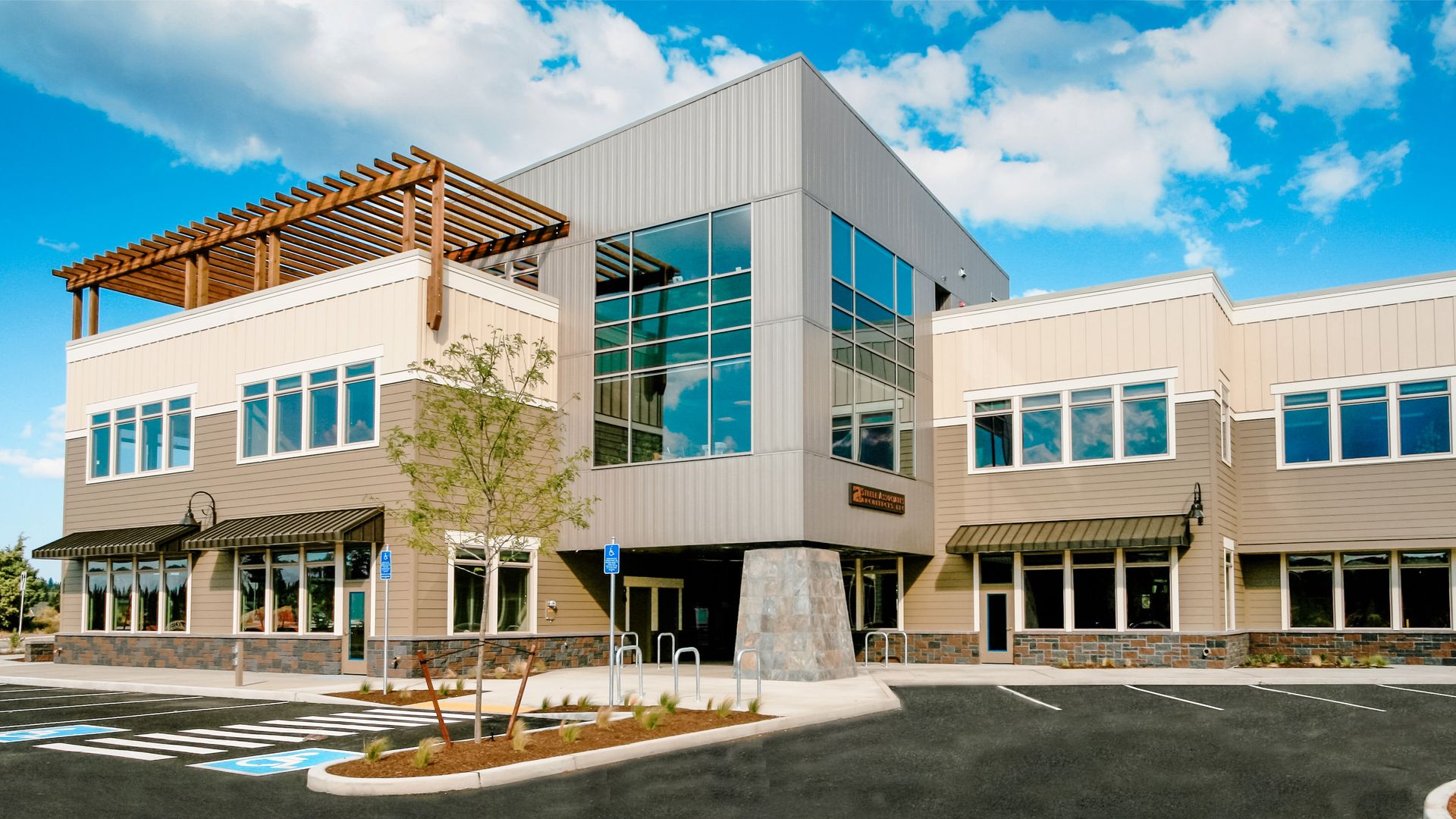 a large building with a lot of windows and a parking lot in front of it