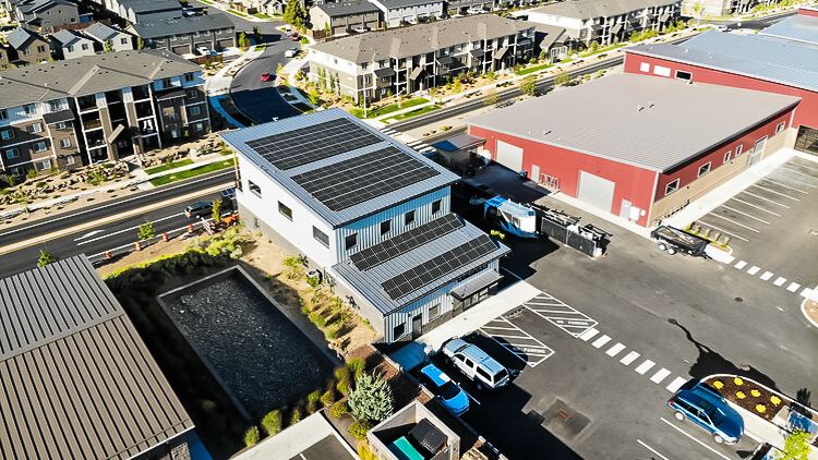 an aerial view of a building with solar panels on the roof .