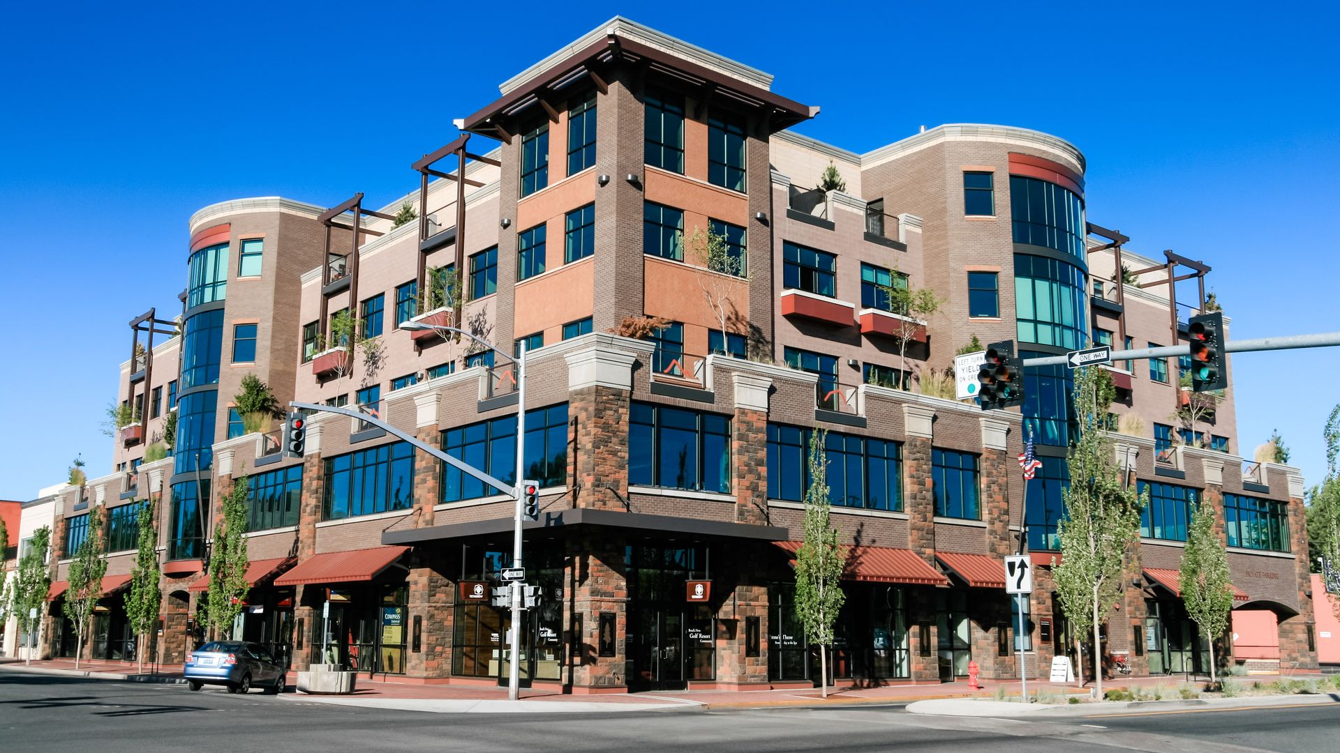 a large building with a lot of windows is on the corner of a street .