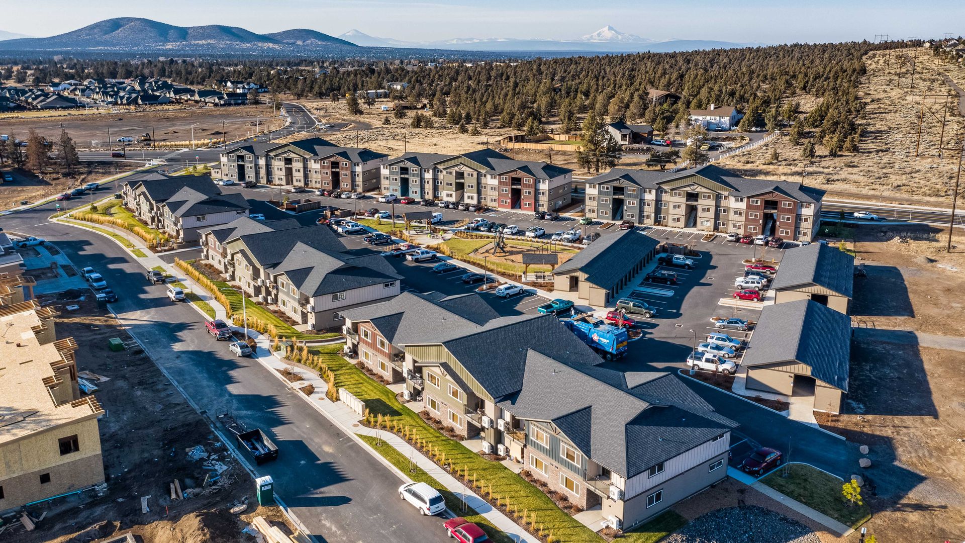 an aerial view of a residential neighborhood with mountains in the background .