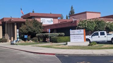 Exterior view of a building with signs for Valley Children's Healthcare, a white truck parked in front.