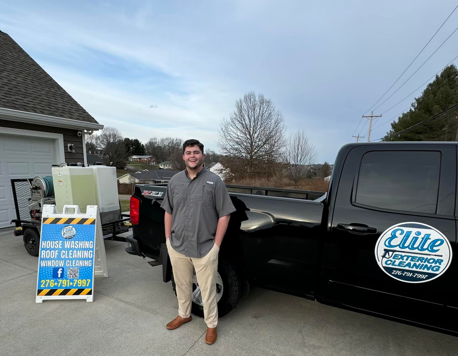 A man is standing next to a truck in a parking lot.