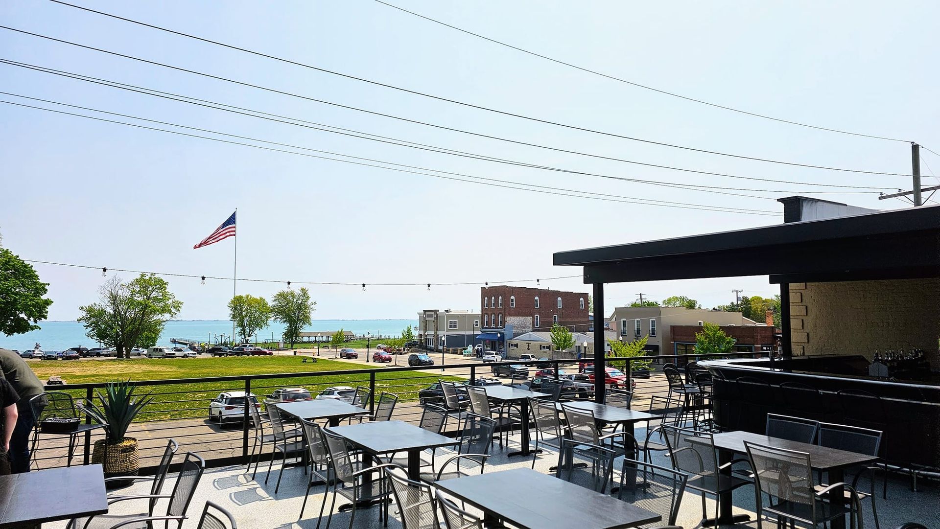 A patio with tables and chairs and a flag flying in the background