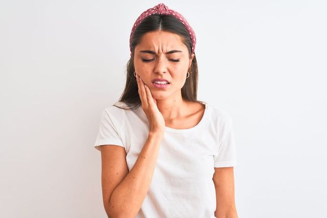 Woman is Holding Her Face in Pain Because of a Toothache — Advanced Cosmetic & Beauty Clinic in Bundaberg South, QLD
