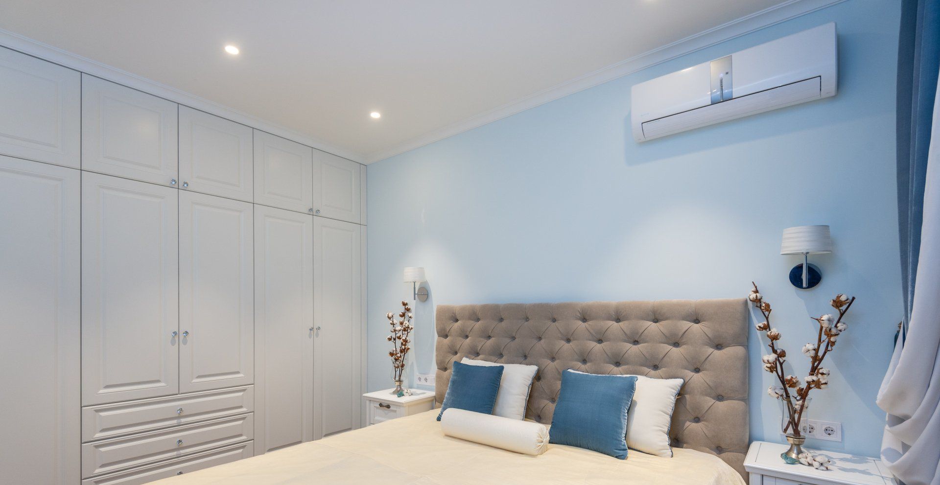 a bedroom with a bed , dresser , nightstand , and blue walls .