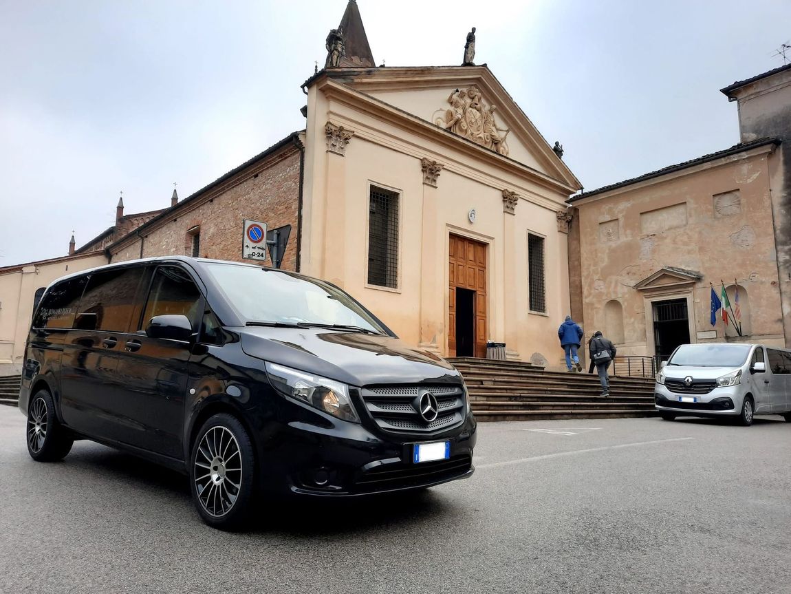 Un furgone nero è parcheggiato davanti a una chiesa.