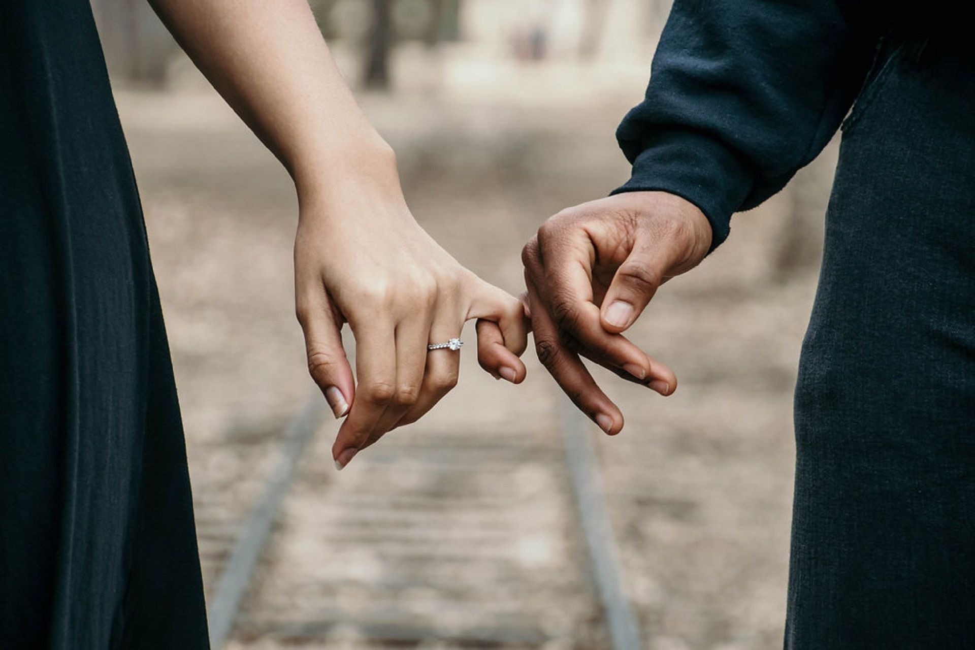 A married couple holding hands but only with the pinky