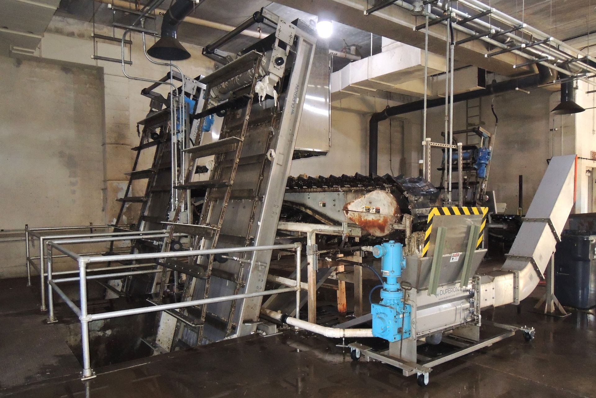 A large machine is in a room with a staircase leading up to it