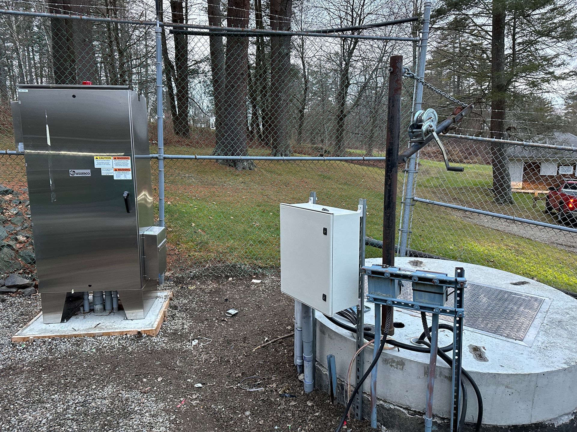A stainless steel box is sitting next to a concrete well.
