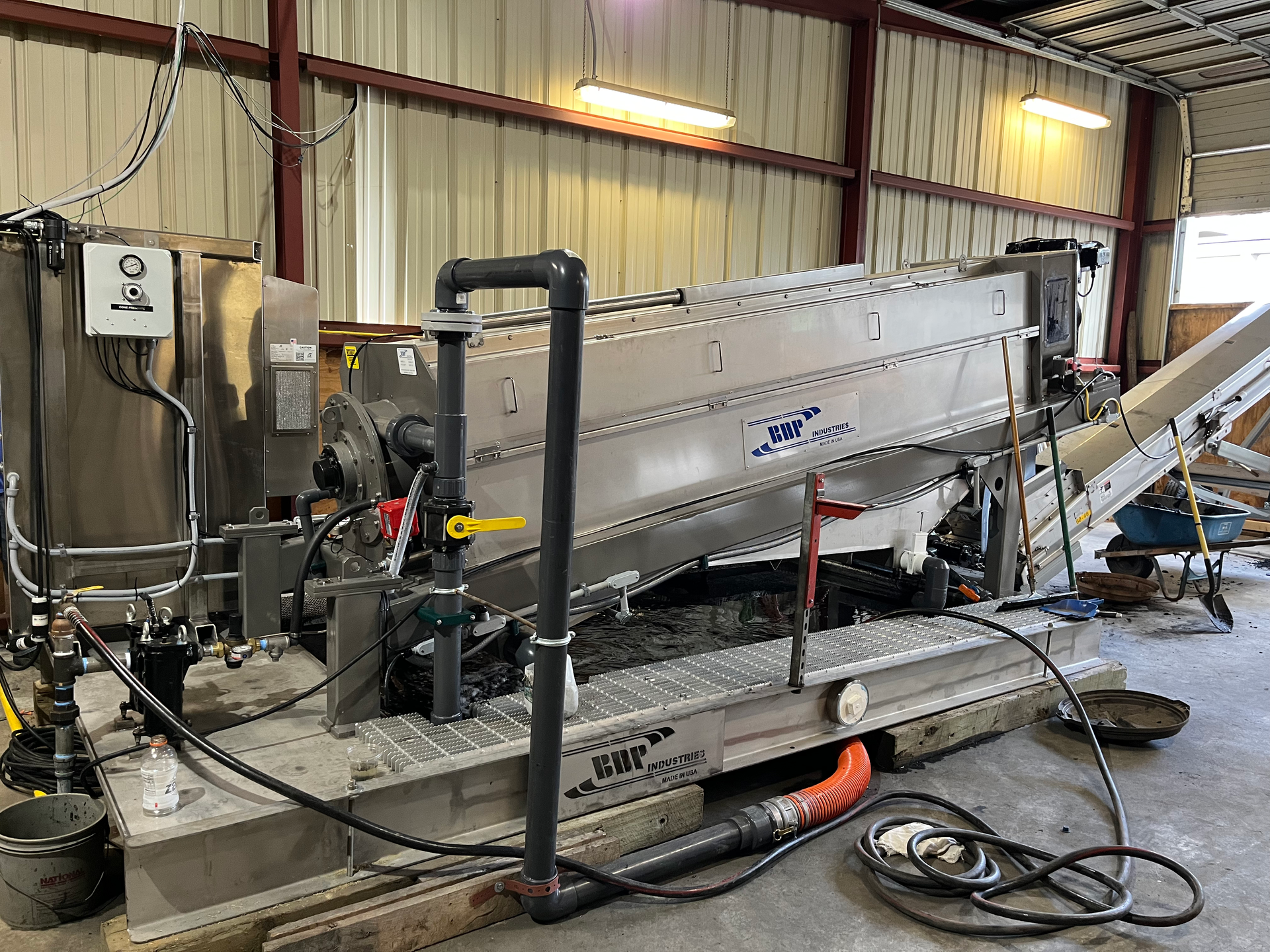 A large stainless steel machine is sitting inside of a building.