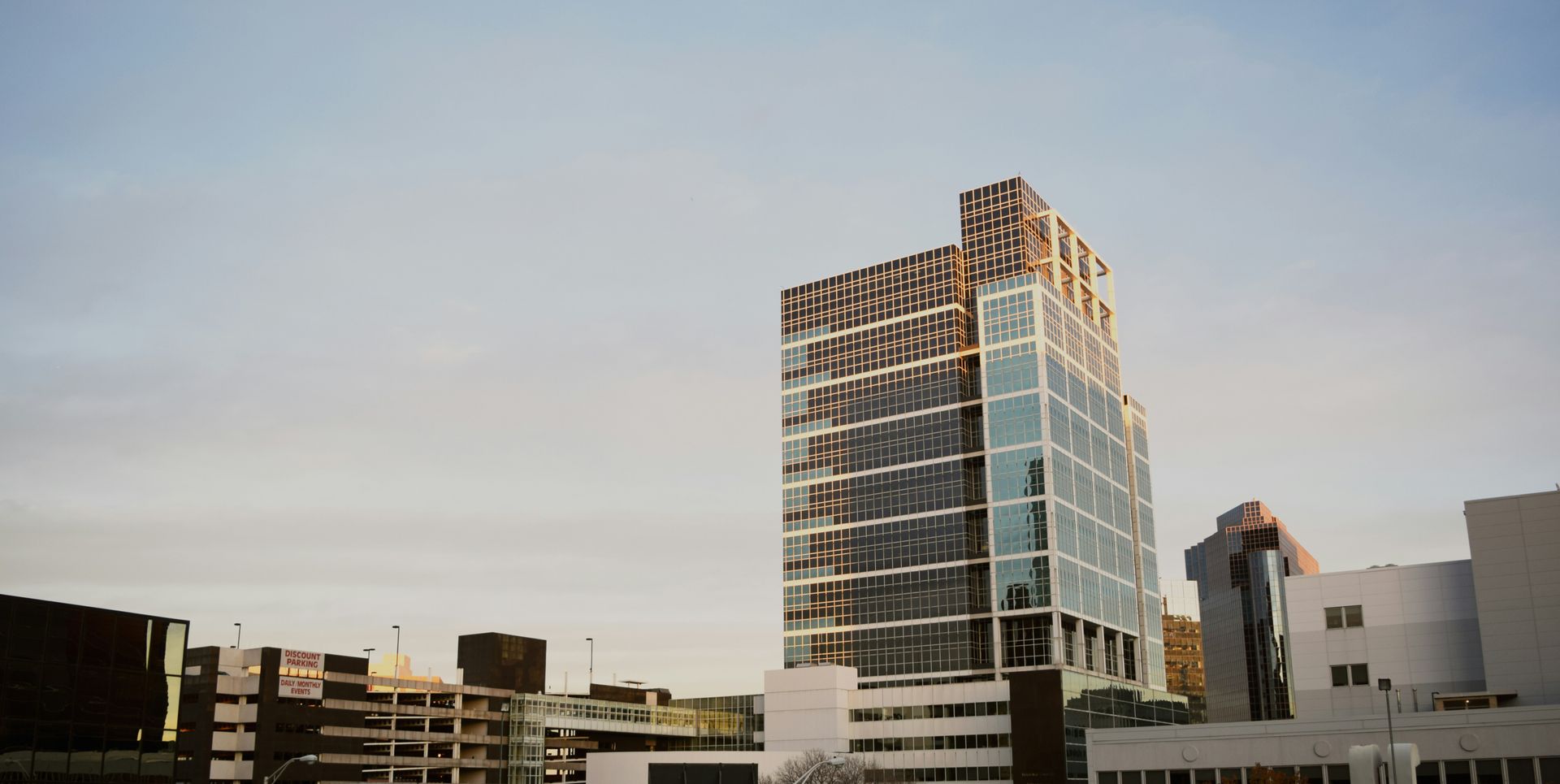 A large building with a lot of windows is in the middle of a city.