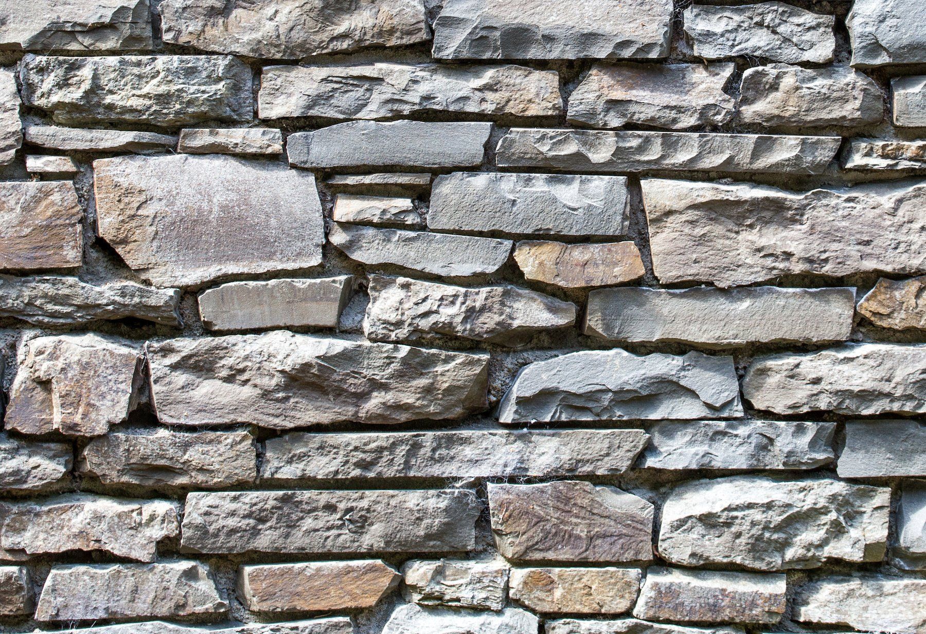 A close up of a stone wall made of different types of rocks.