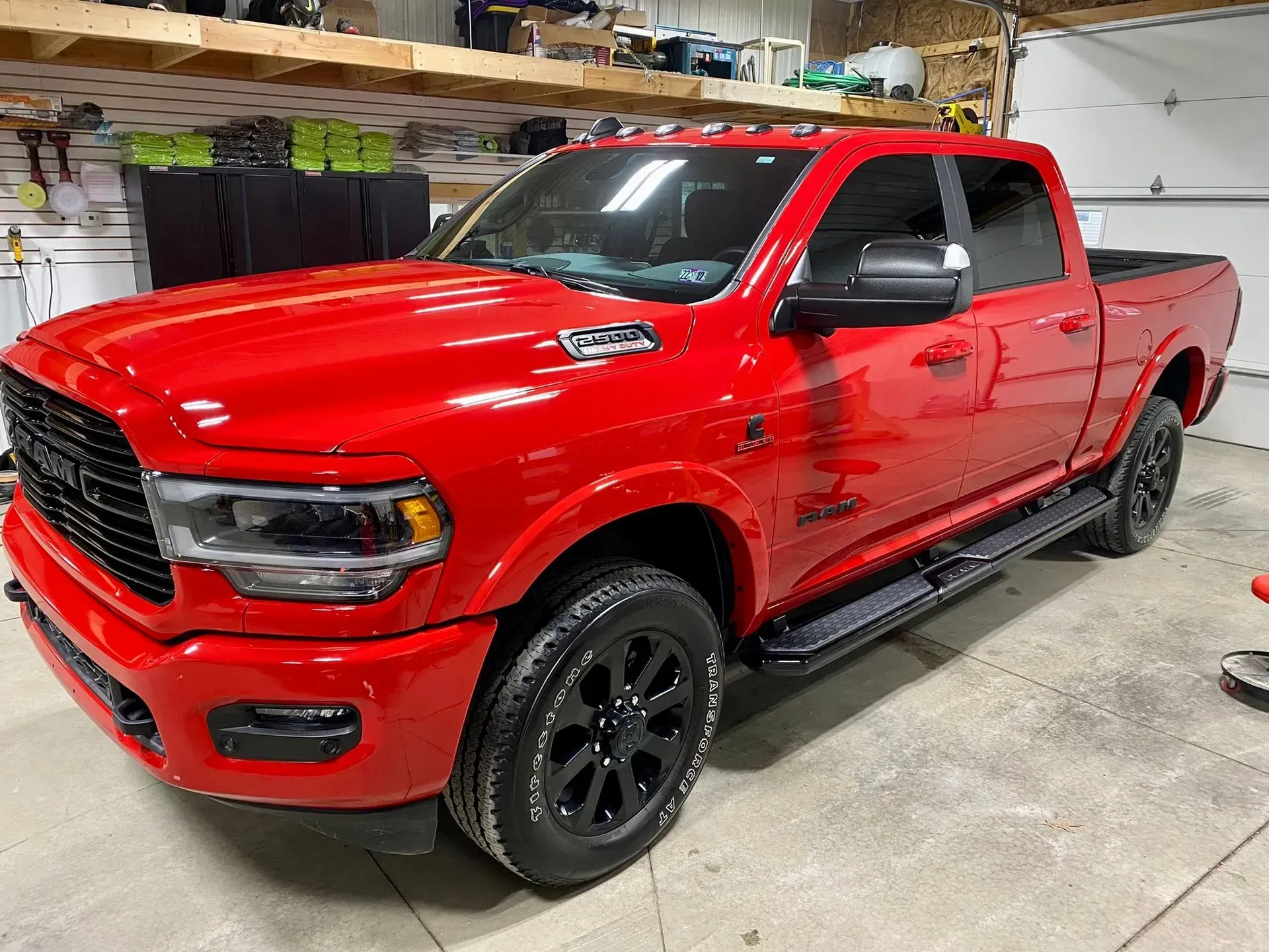 Red pickup truck in a garage, shown from the front-left side.