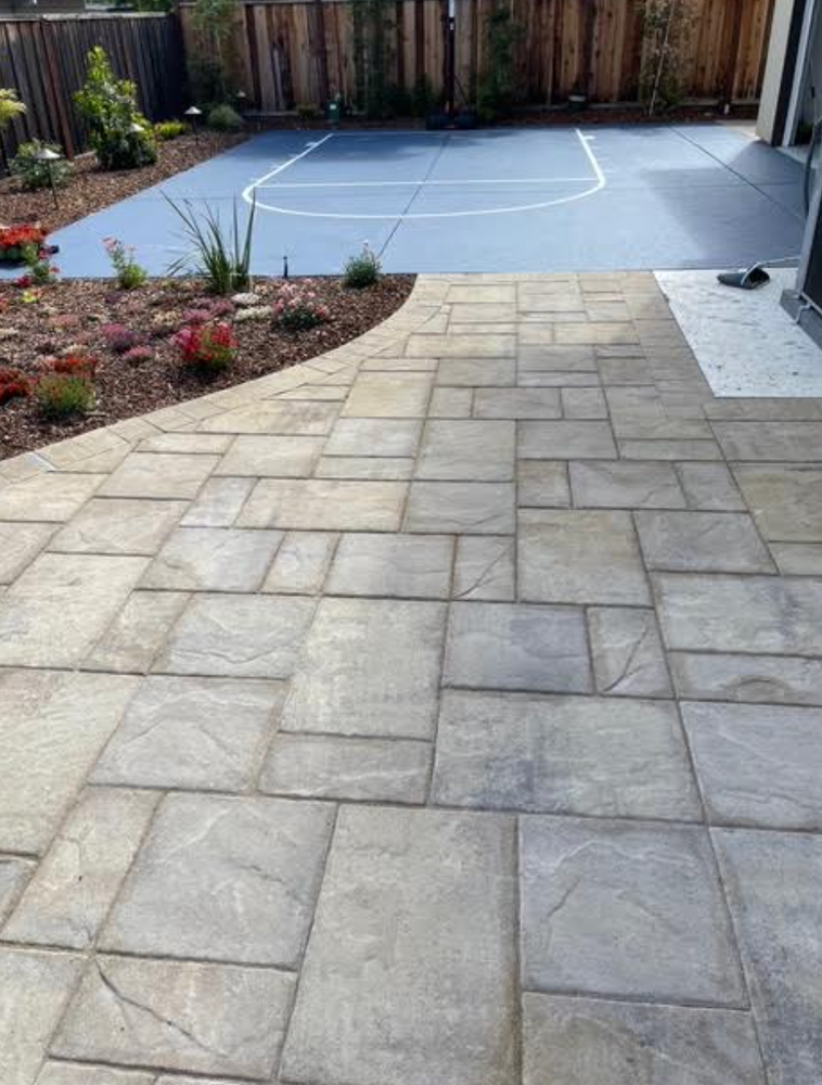 A patio with a basketball court in the background.