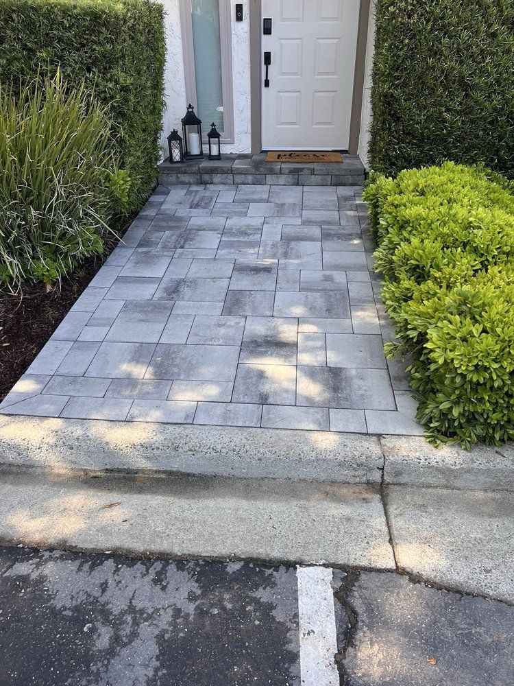 A walkway leading to a white door with lanterns on it