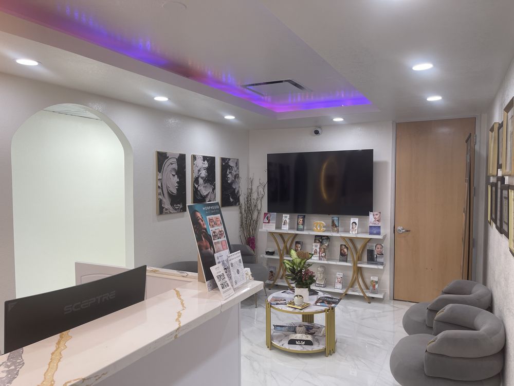 A waiting room with a table , chairs , and a television.