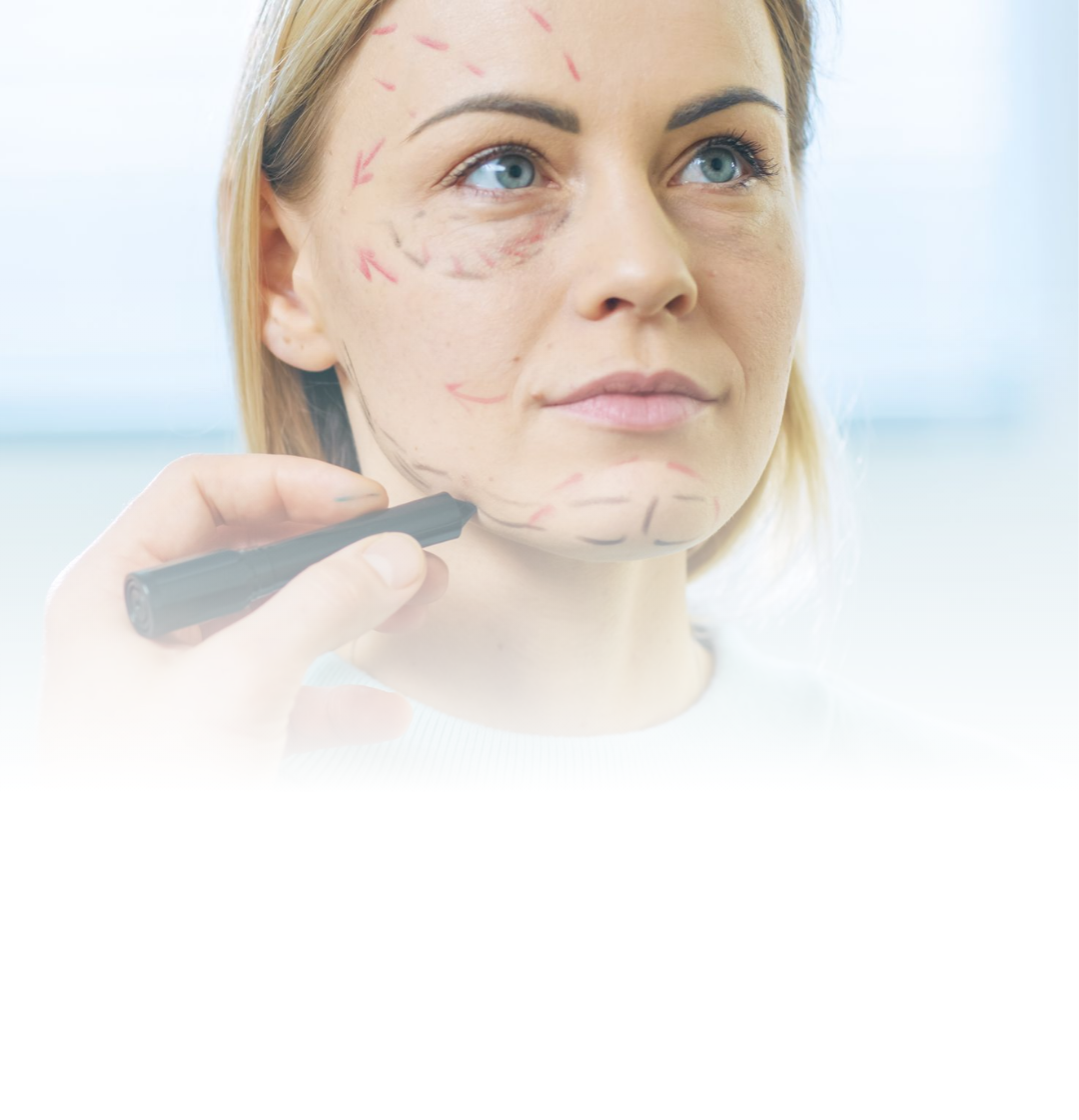 Mulher recebendo maquiagem facial com um pincel enquanto olha para cima em um estúdio bem iluminado.