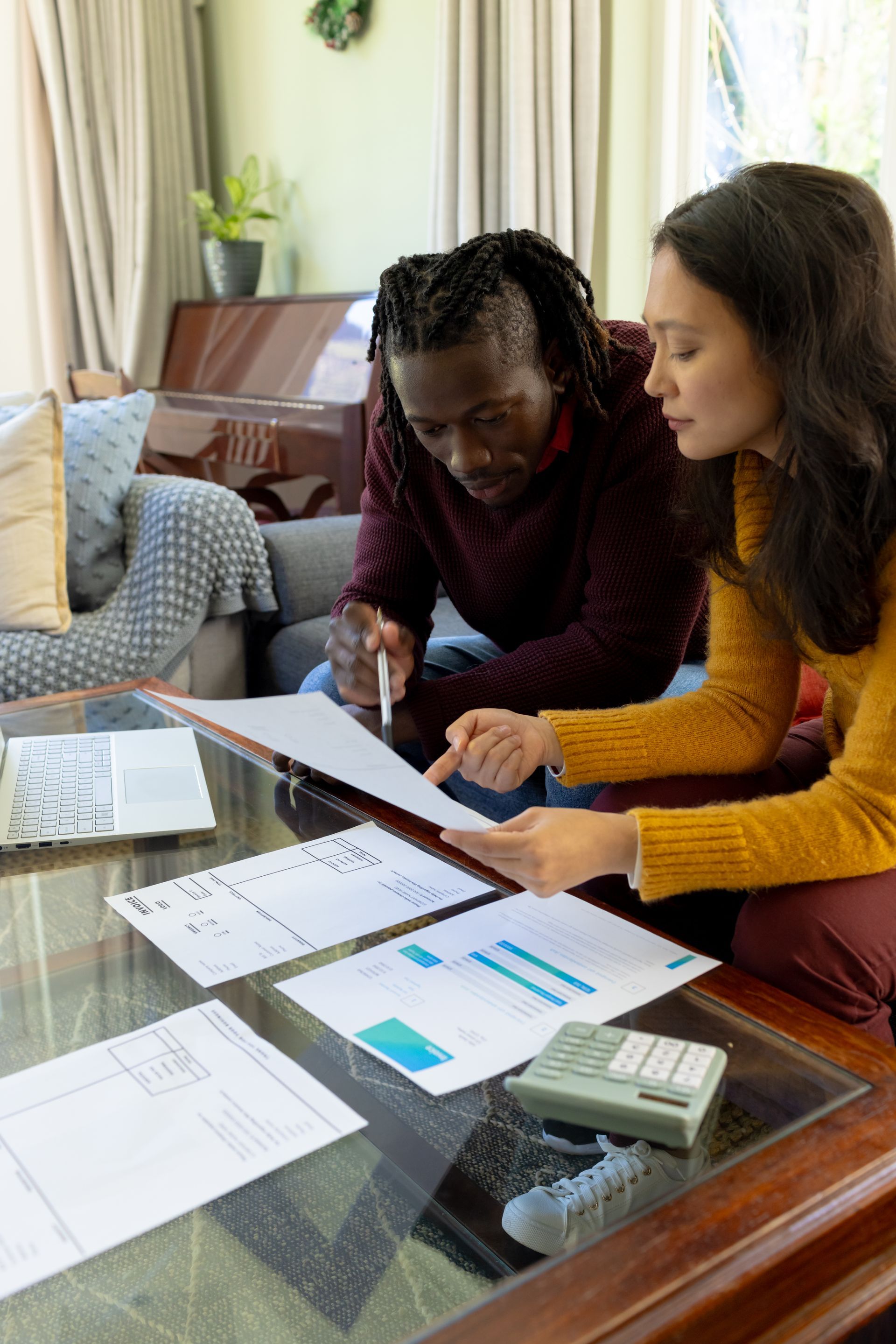 a man and a woman are sitting at a table looking at papers .