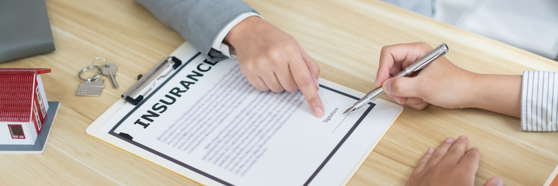 A person is signing a document on a clipboard.