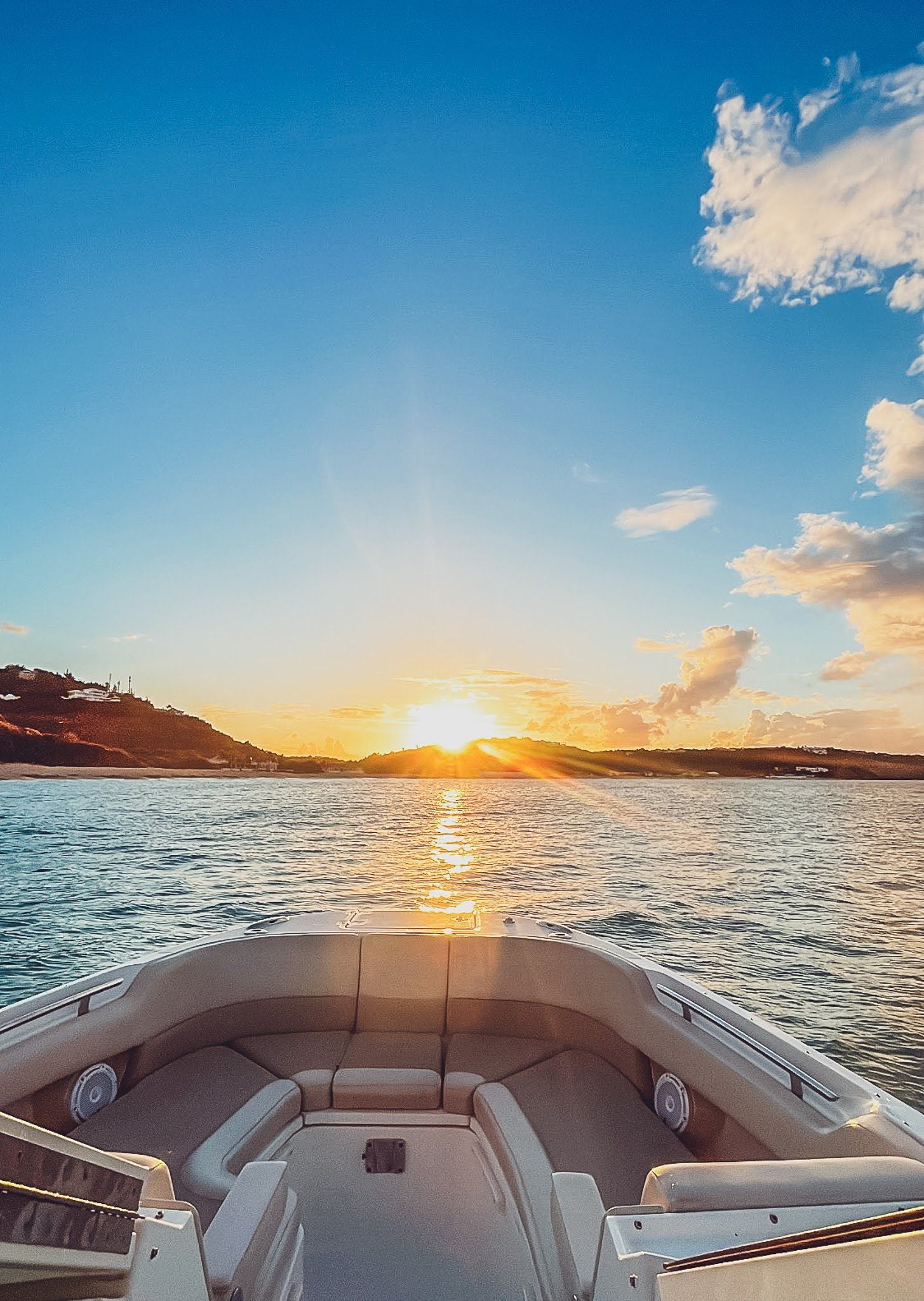 A boat is floating on top of a body of water at sunset.