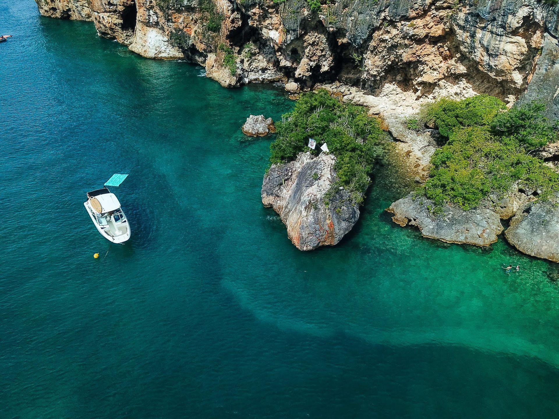 An aerial view of a boat in the middle of a body of water.