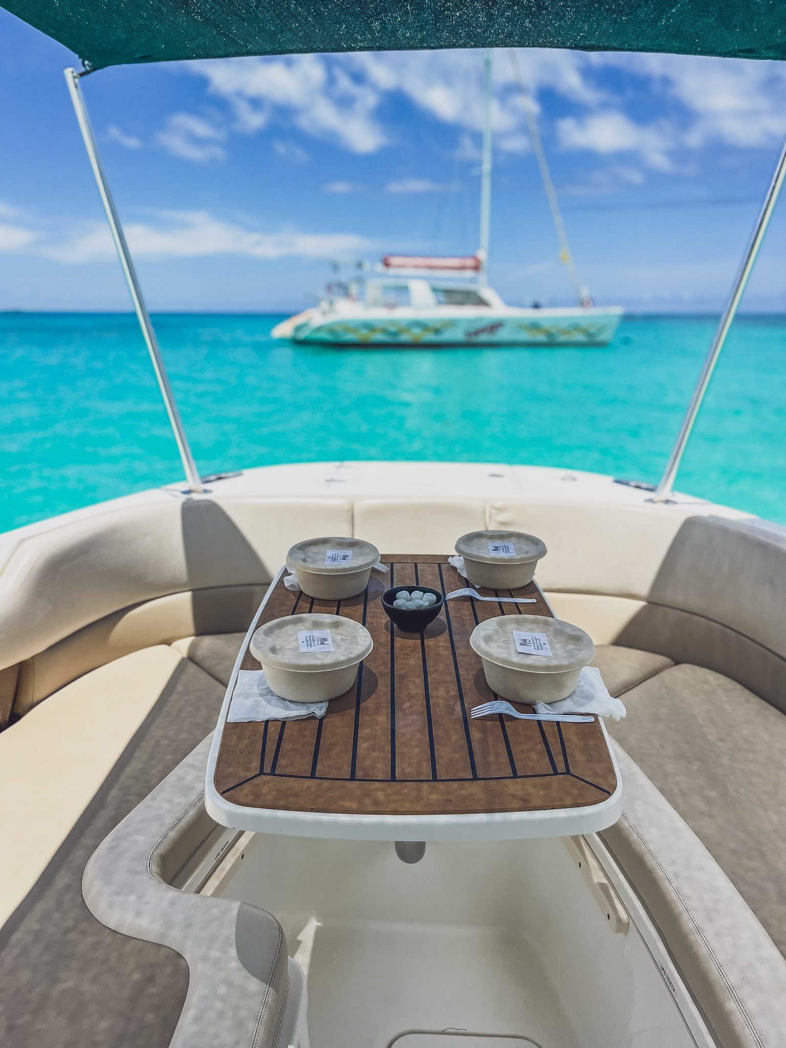 A boat with a table and bowls on it is in the ocean.