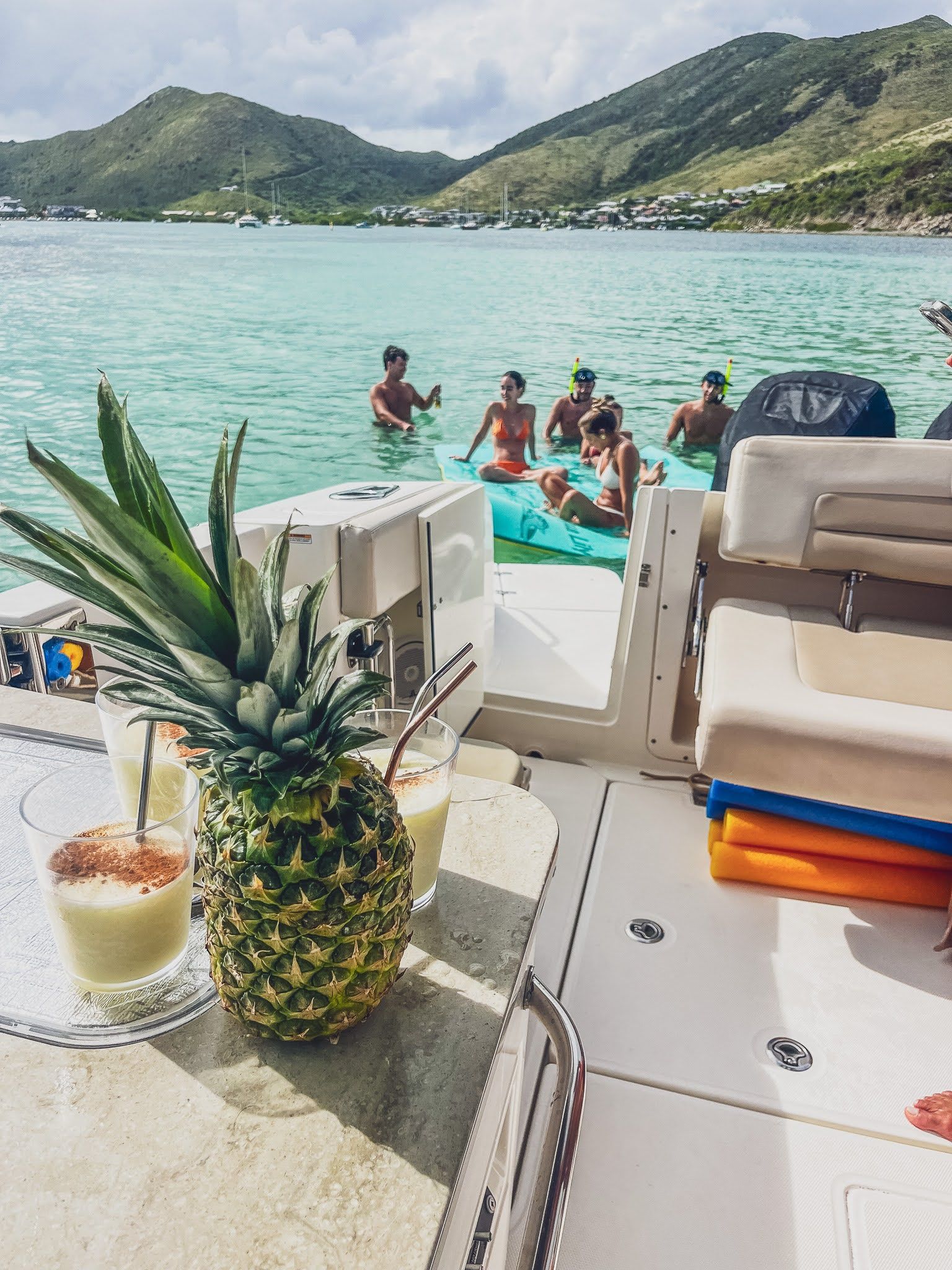 A group of people are swimming in the ocean on a boat.