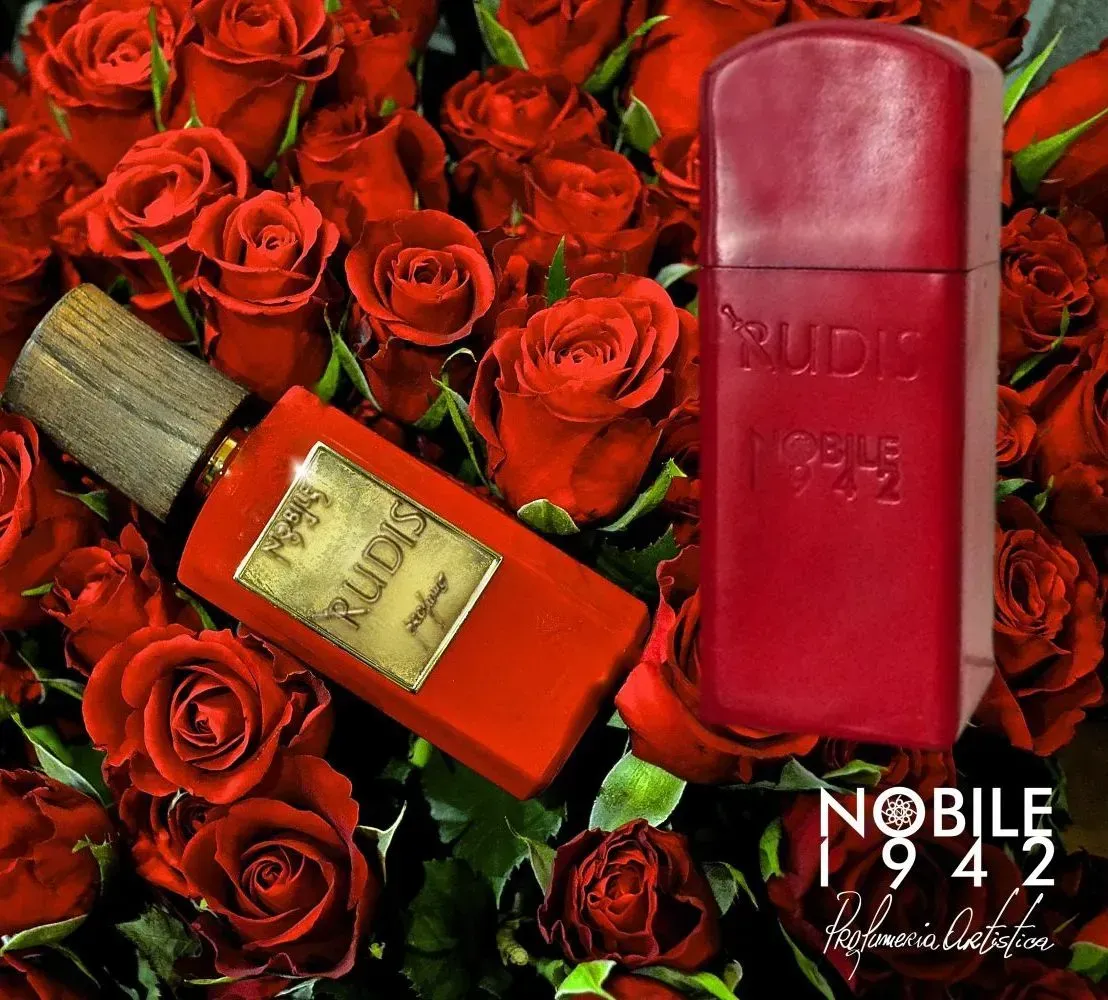 Flacone e astuccio di profumo rossi tra rose rosse, con il marchio 