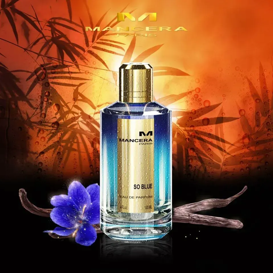 Flacone di profumo Mancera Soleil con tappo dorato, liquido blu, fiore viola su sfondo arancione scuro.