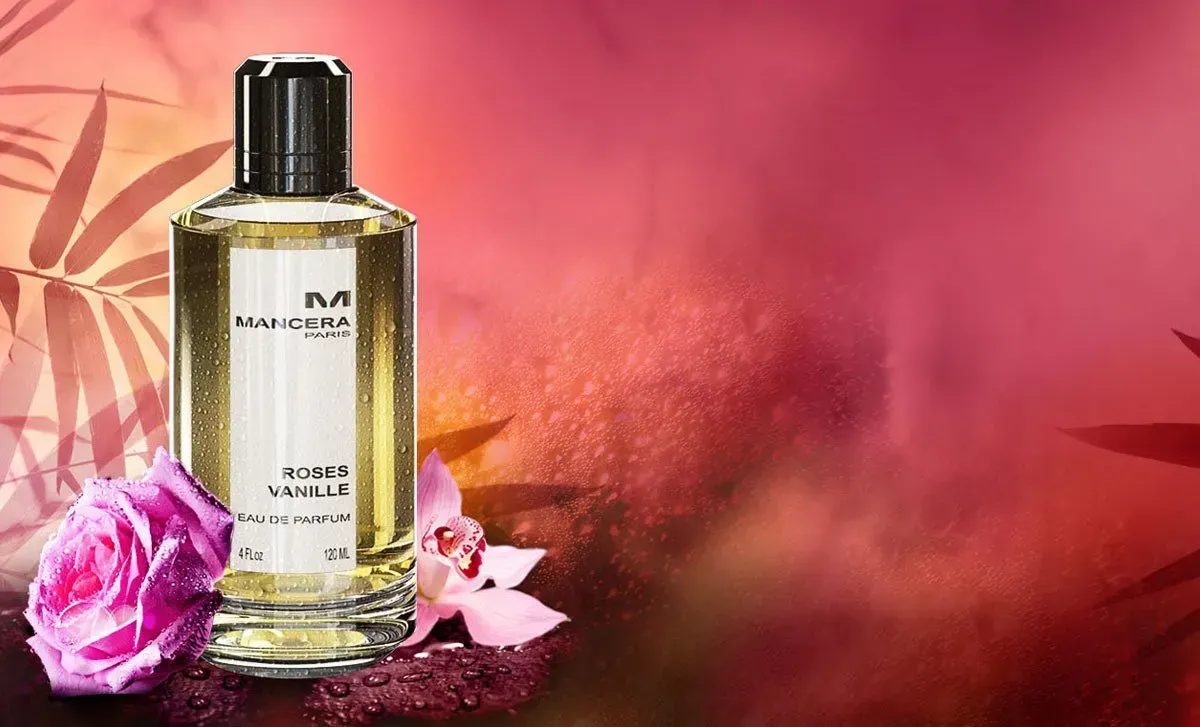 Flacone di profumo con fiori rosa su uno sfondo rosa caldo.