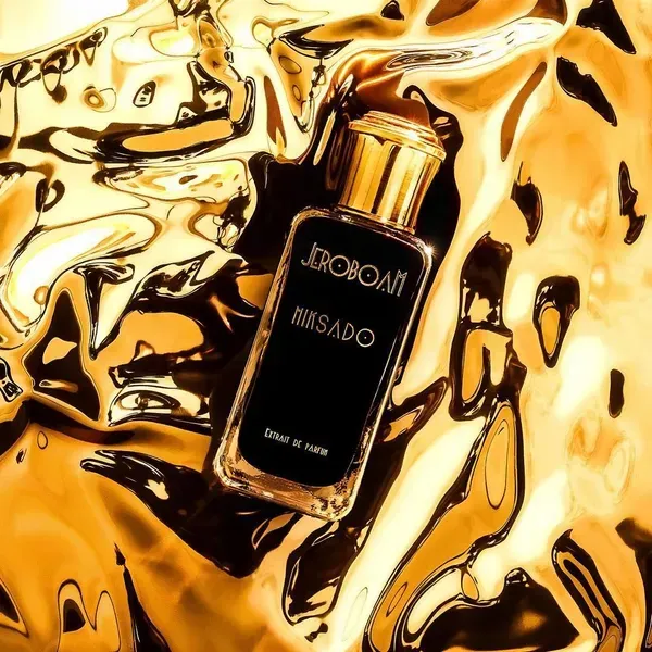 Flacone spray nero JOBOANI su sfondo dorato, effetto liquido