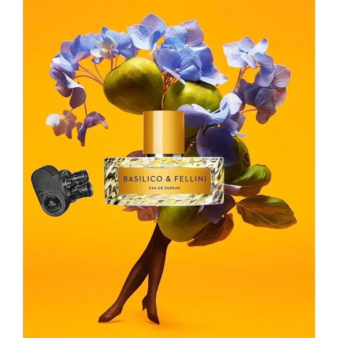 Flacone di profumo Baylis & Harding con fiori blu su sfondo arancione brillante.