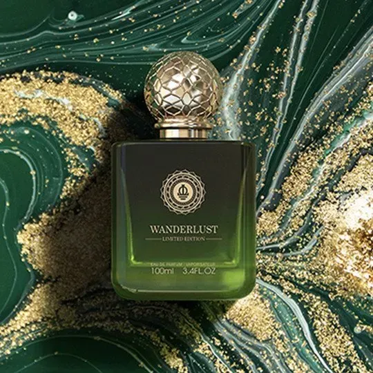 Flacone di profumo Wanderlust verde su uno sfondo marmorizzato color smeraldo e oro.
