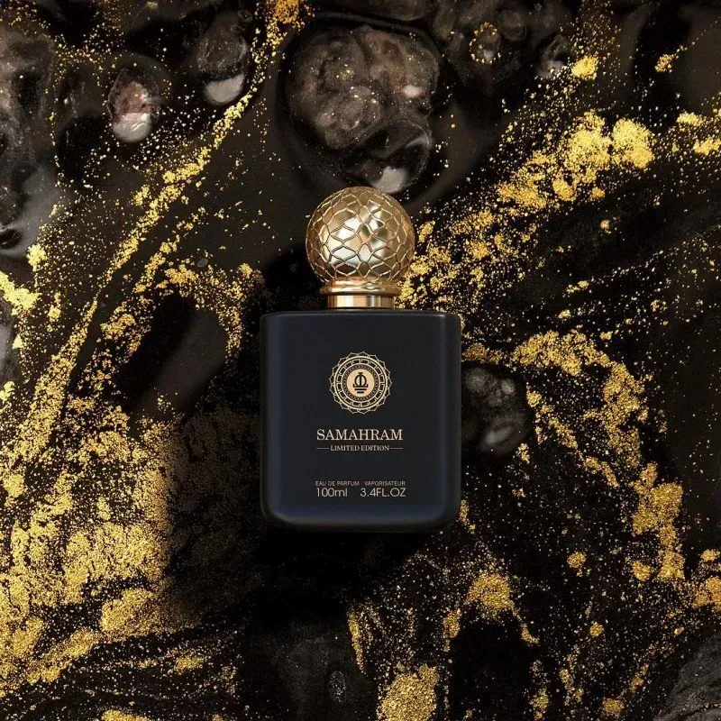 Flacone di profumo nero con tappo dorato su sfondo scuro punteggiato d'oro.
