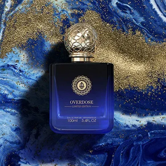 Flacone di profumo blu con tappo dorato su sfondo marmorizzato blu e oro.
