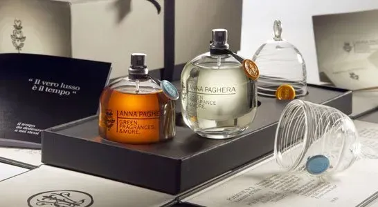 Flaconi di profumo di lusso su un vassoio espositivo, tra cui flaconi in vetro ambrato