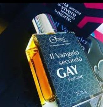 Flacone di profumo con la scritta “Il Vangelo secondo GAY” su sfondo scuro, con liquido ambrato e tappo argentato.
