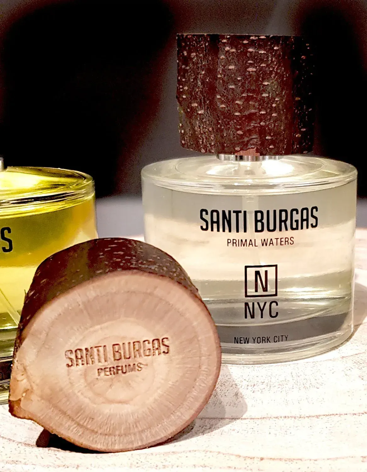 Su un tavolo sono disposte boccette e tappi di profumo Santi Burgas