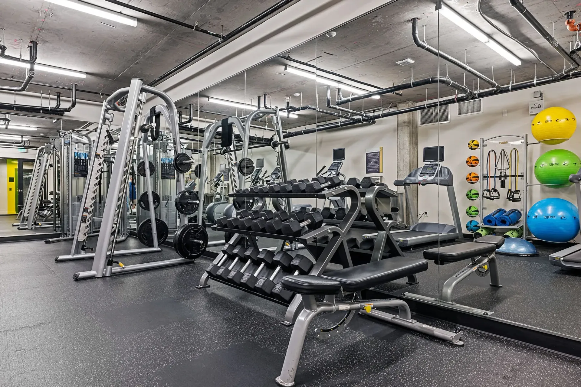 Fully equipped fitness center with weight machines, free weights, and treadmills.