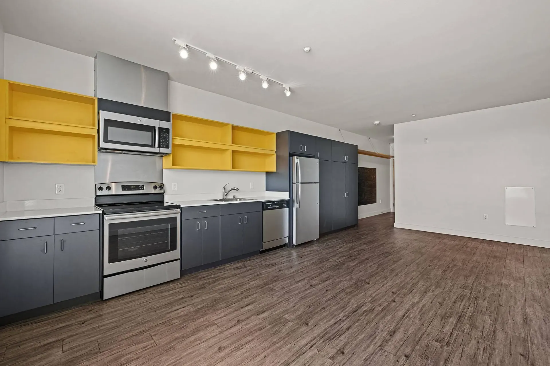 Modern kitchen with stainless steel appliances and gray cabinets.